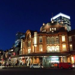 Illuminated buildings against blue sky at night