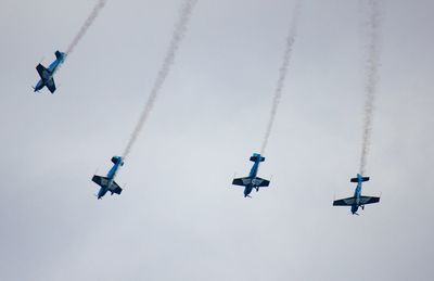 Low angle view of airshow against sky