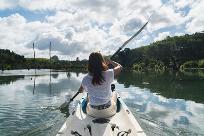 Rear view of woman on lake against sky