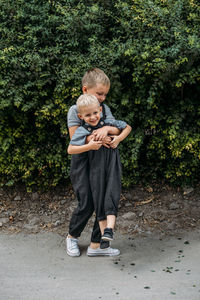 Two brother kids siblings play together near house. two little boys embrace brotherly and having fun 