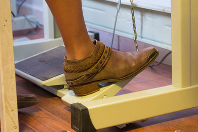 Low section of woman using sewing machine