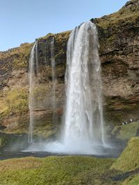 Scenic view of waterfall against sky