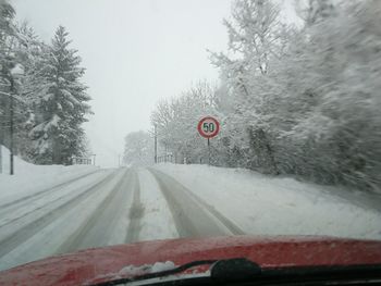Road seen through car windshield during winter