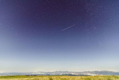 Scenic view of landscape against star field at dawn