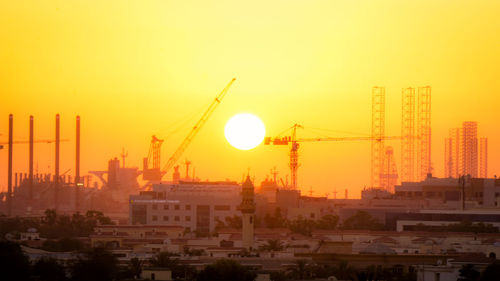 Construction site against sky during sunset