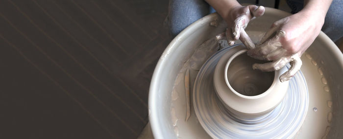 Potter's hands. an artisan works on a potter's wheel and makes a vase. creating ceramics.