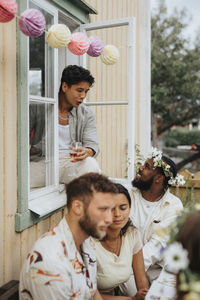 Young multiracial male friends talking to each other during dinner party at cafe