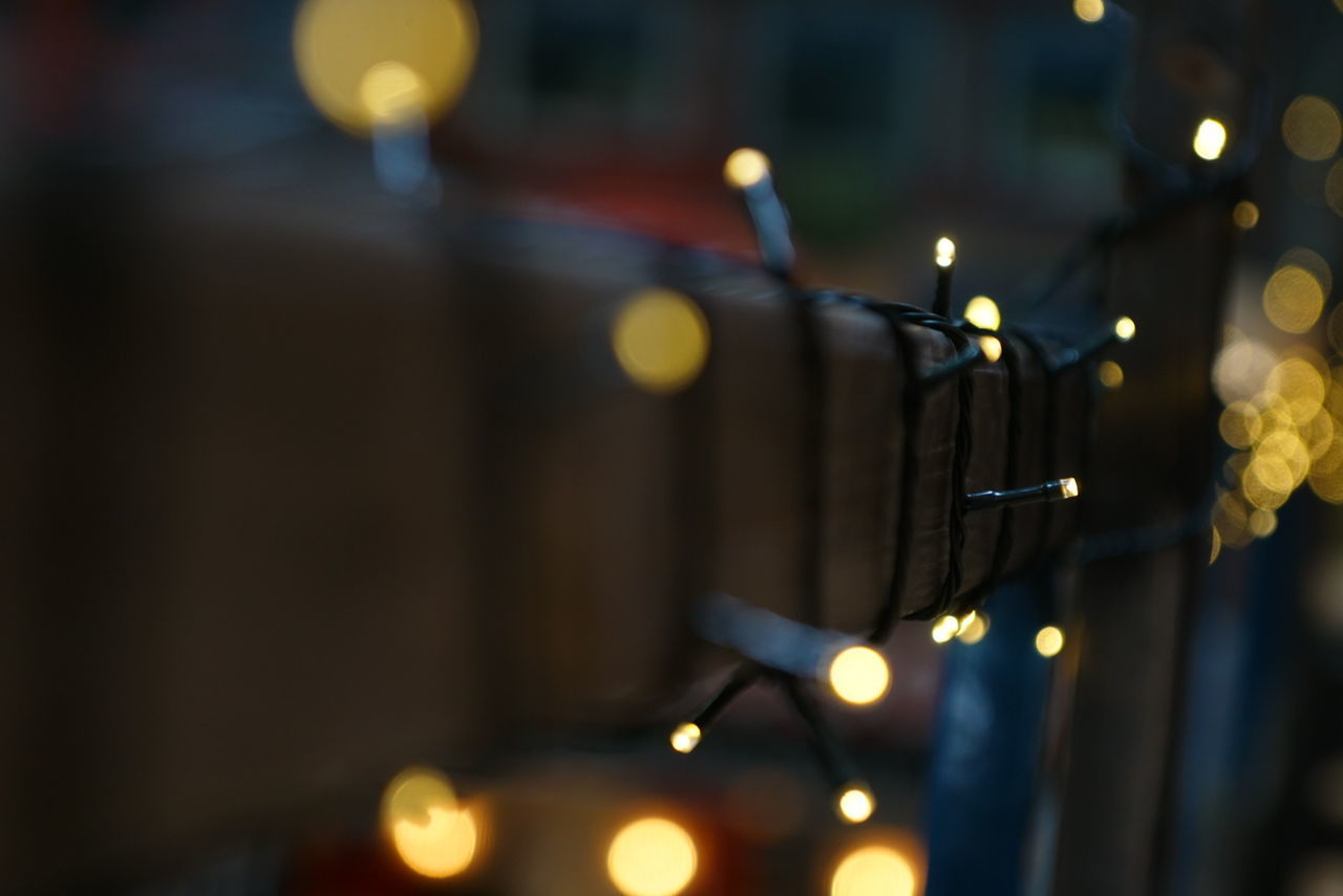 CLOSE-UP OF ILLUMINATED CANDLES ON WALL