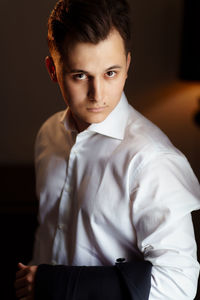 Portrait of young man standing at home