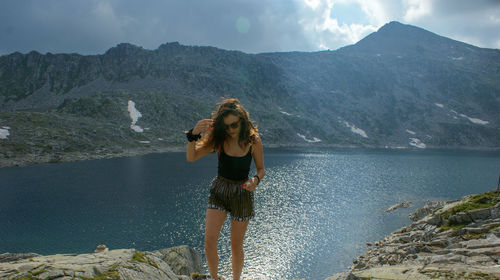 Woman standing on mountain against sky