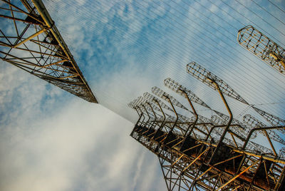 Low angle view of cranes against sky