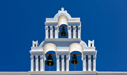 Low angle view of bell tower against clear blue sky