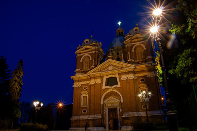 Low angle view of illuminated building against sky at night