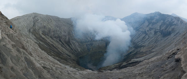 Smoke emitting from volcanic mountain against sky