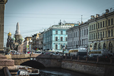 Bridge over river against buildings in city