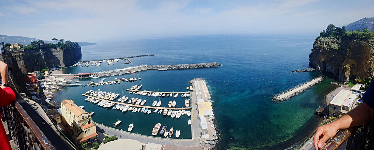 sea, water, high angle view, built structure, horizon over water, sky, architecture, building exterior, panoramic, travel, tourism, incidental people, travel destinations, transportation, nautical vessel, large group of people, mode of transport, famous place, beach, nature