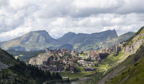 Panoramic view of buildings in city against cloudy sky