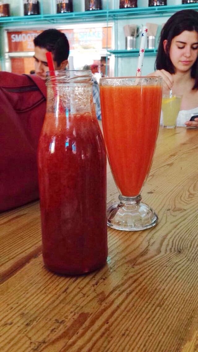 drink, food and drink, table, refreshment, drinking glass, indoors, lifestyles, restaurant, leisure activity, freshness, alcohol, red, glass - material, incidental people, glass, sitting, focus on foreground