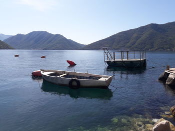 Boat moored in lake against sky