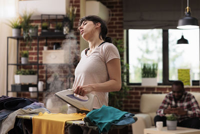 Young woman using mobile phone while standing in cafe