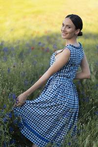 Portrait of young woman standing on field