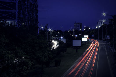 Light trails on road against sky at night