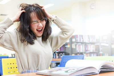 Frustrated young woman sitting in library