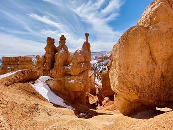 Rock formations on landscape against cloudy sky