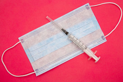 High angle view of pen on table against red background