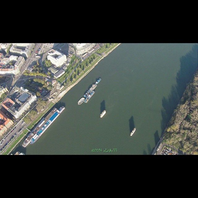 water, high angle view, architecture, transfer print, built structure, building exterior, flying, aerial view, auto post production filter, city, transportation, cityscape, reflection, window, transparent, mode of transport, day, elevated view, indoors, river