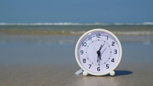 Close-up of clock on the beach