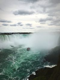 Scenic view of waterfall against sky