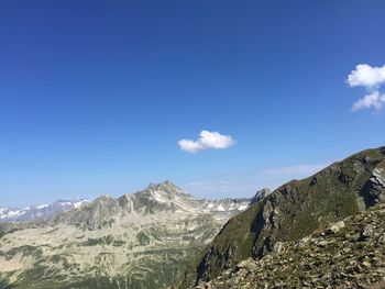 Scenic view of mountains against blue sky