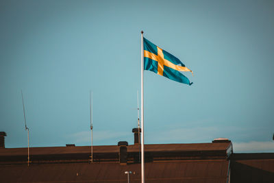 Beautiful swedish flag swaying in light wind in late summer night