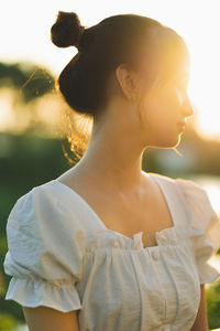 Side view of woman holding flower