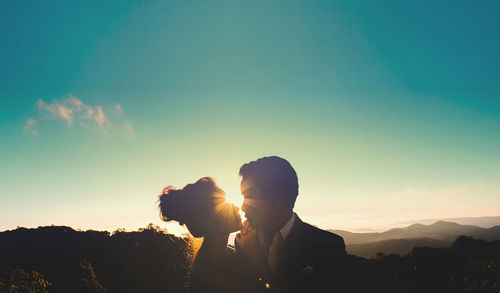 Silhouette people standing against sky during sunset