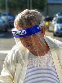 Portrait of elderly woman with text on covid mask