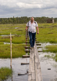 Rear view of woman walking on boardwalk