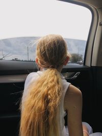 Rear view of girl against car window