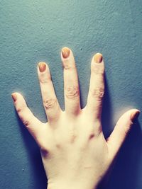 Close-up of human hand against wall