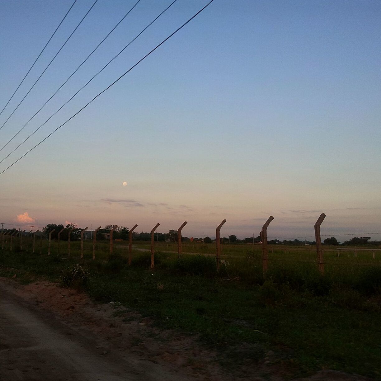 field, landscape, clear sky, tranquility, sunset, tranquil scene, rural scene, sky, nature, grass, electricity pylon, copy space, power line, scenics, fuel and power generation, agriculture, beauty in nature, farm, outdoors, no people