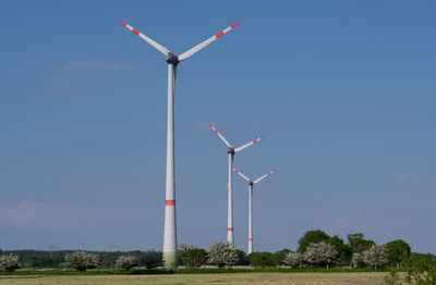 Low angle view of windmill on field against sky