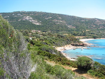 Scenic view of sea by mountains against sky
