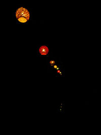 Low angle view of illuminated lights against clear sky at night