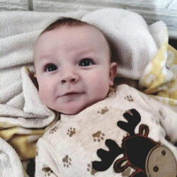 Portrait of cute baby lying on bed