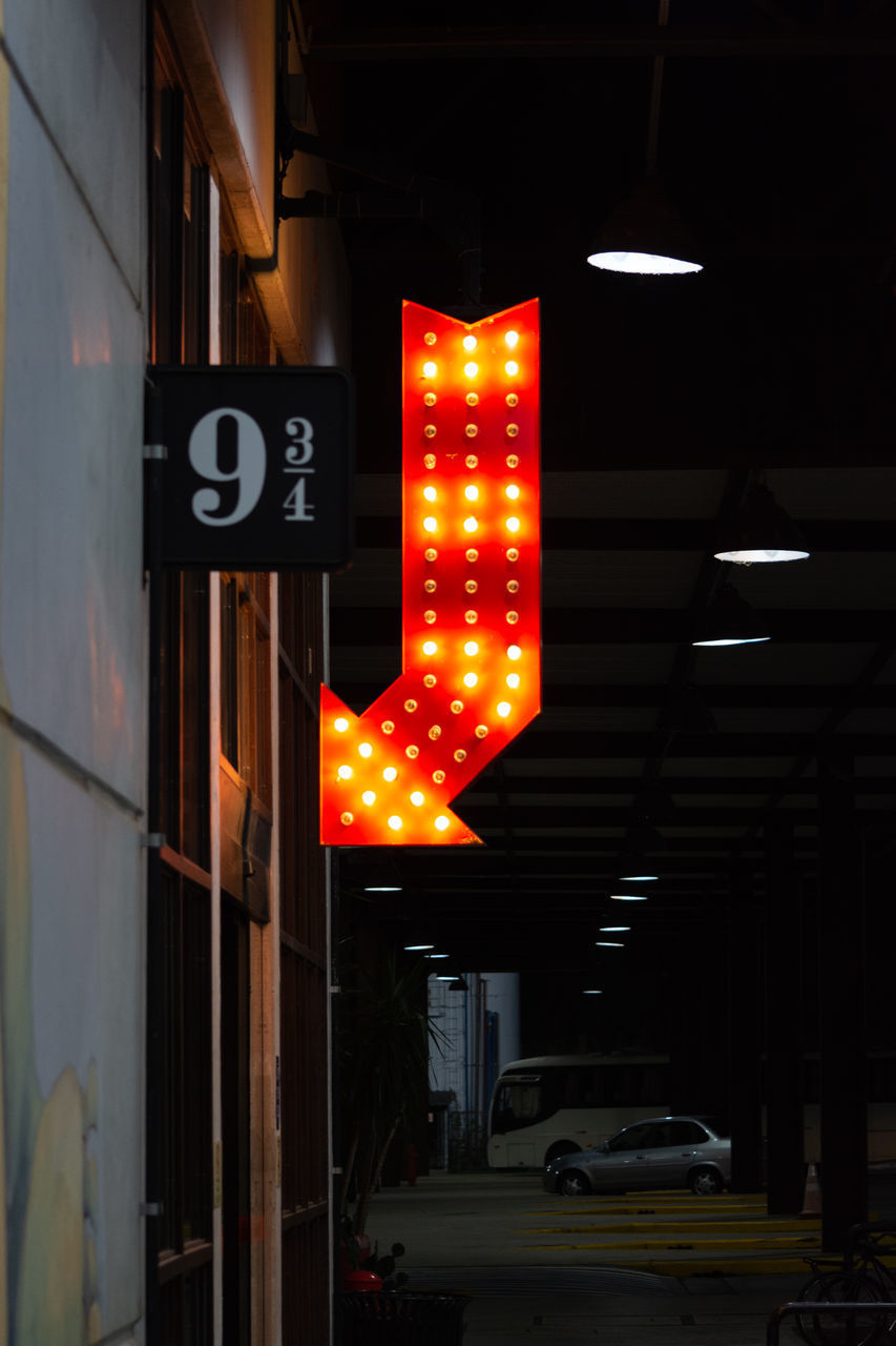 ILLUMINATED ROAD SIGN ON STREET IN CITY