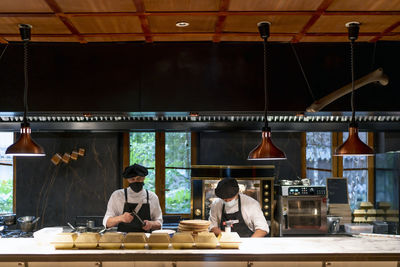 Chefs wearing protective face mask standing in restaurant