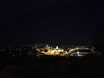 Illuminated city against sky at night
