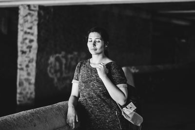 Thoughtful woman with eyes closed standing in tunnel