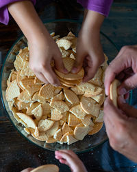 Midsection of children crushing cookies  in bowl. top view